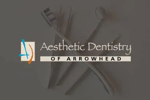 Aesthetic Dentistry of Arrowhead logo over a photo of dental tools